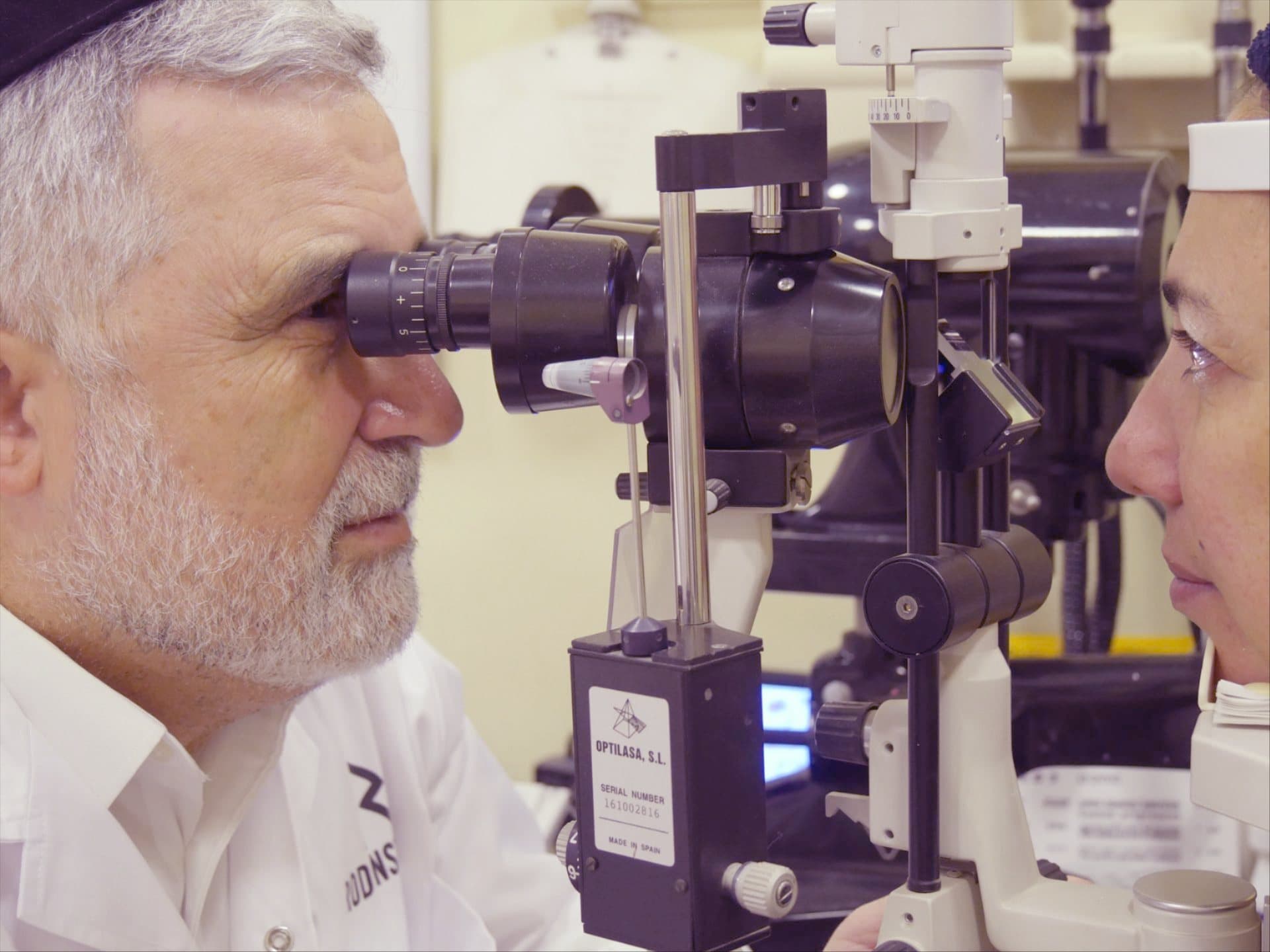 Optometrist Aryeh Turgeman examining a patient with a slit lamp